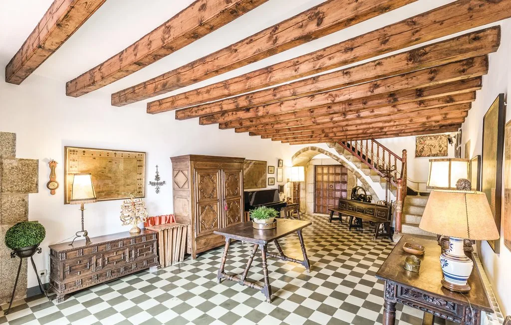 Una sala amueblada con vigas de madera expuestas y suelo de baldosas a cuadros.