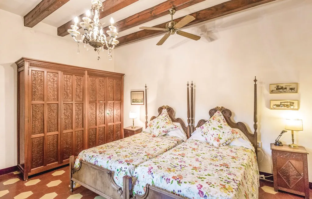 Un dormitorio con dos camas, ropa de cama floral y un gran armario de madera.