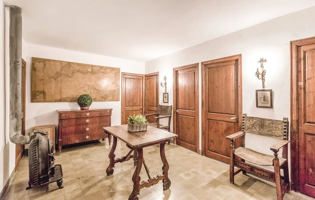 Una habitación amueblada con puertas de madera, una mesa y una silla.