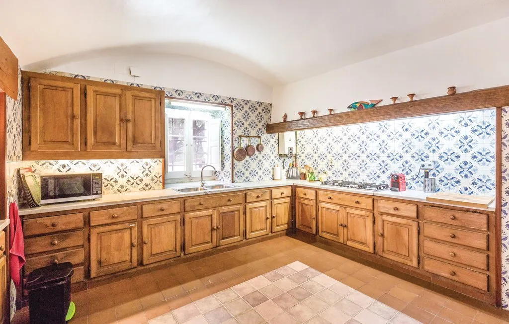 Una cocina alicatada con armarios de madera y encimeras.