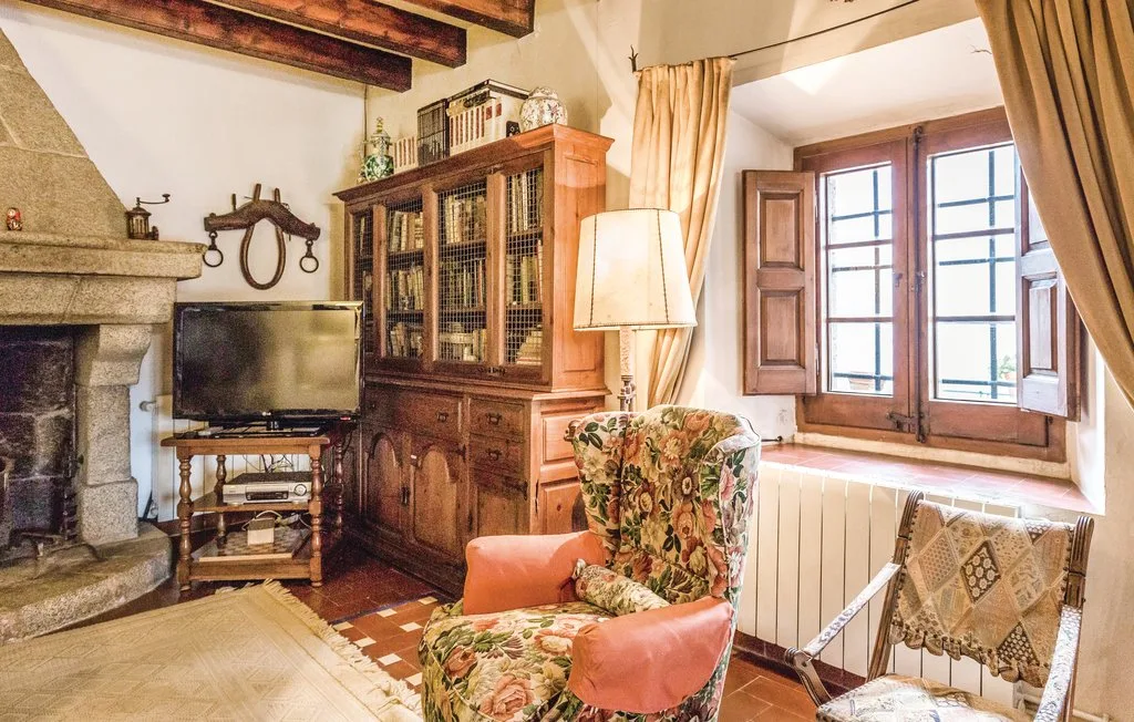 Una sala de estar con un mueble de madera, sillones y una ventana grande.