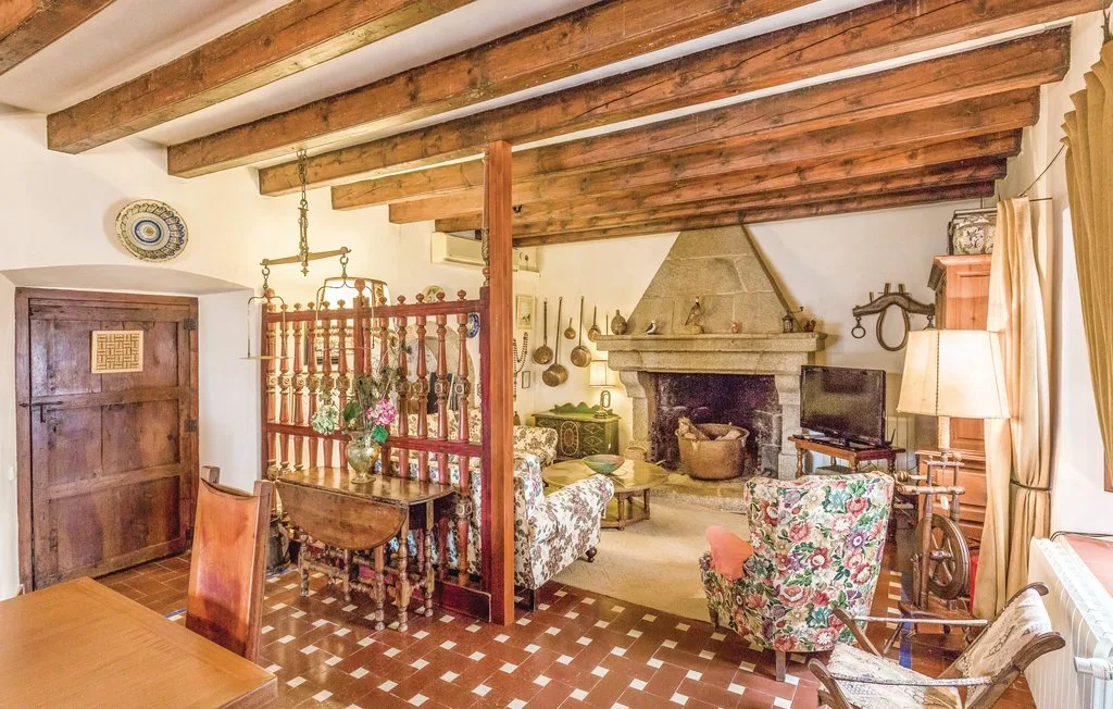 Una sala rústica con vigas de madera expuestas y una gran chimenea.