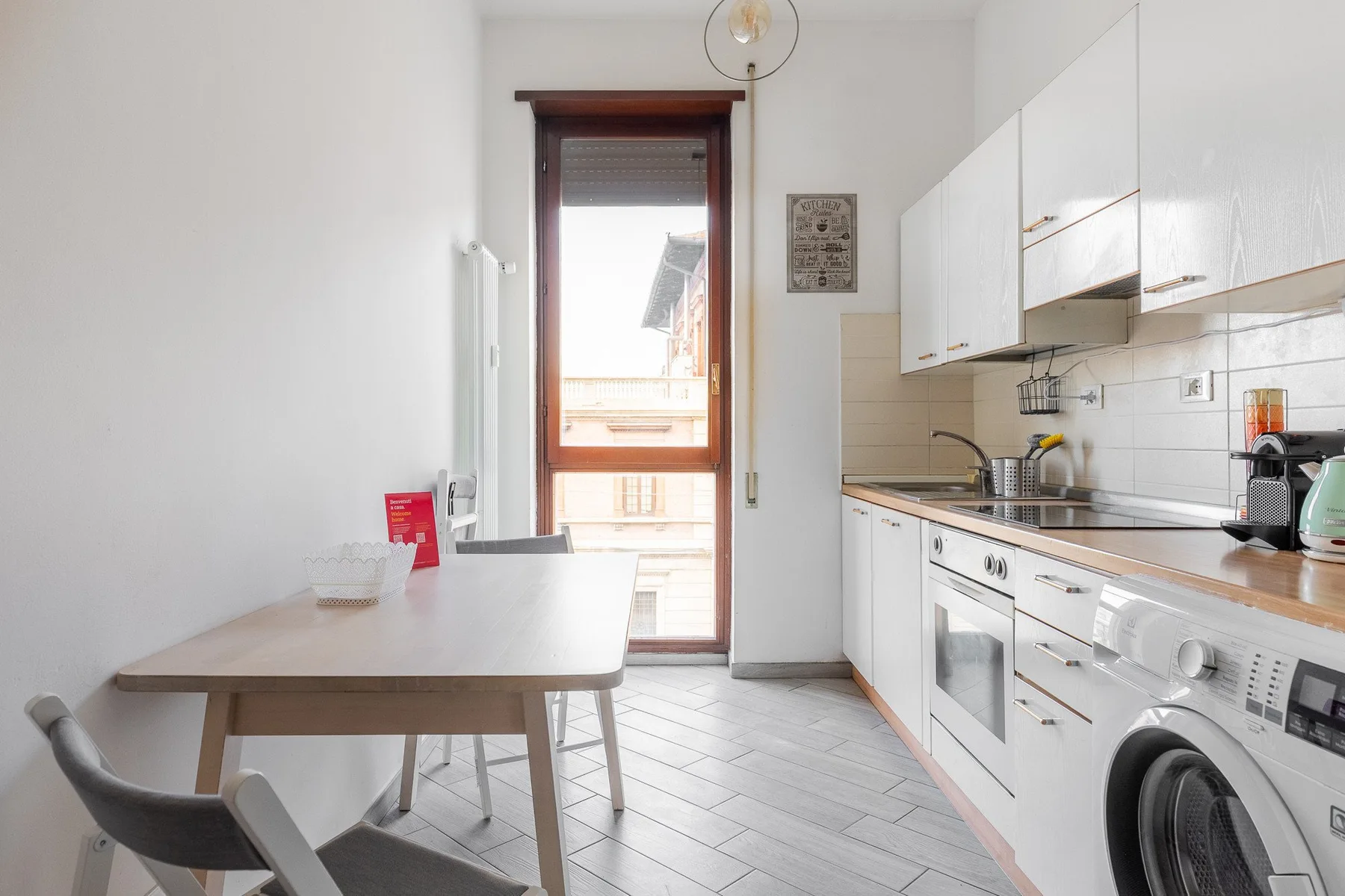 A bright kitchen with a dining table beside a window and a long counter.