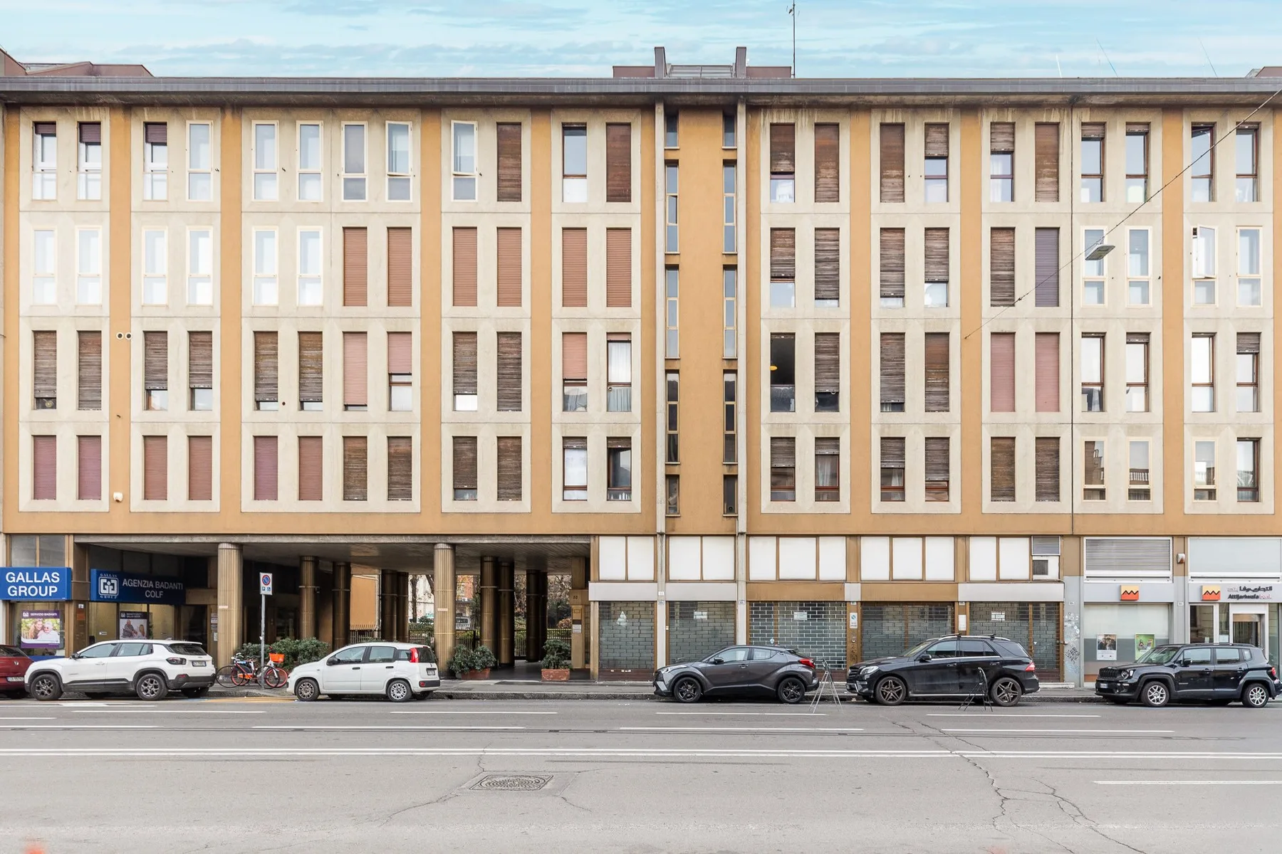 A multistory building with rows of windows and shops at street level.