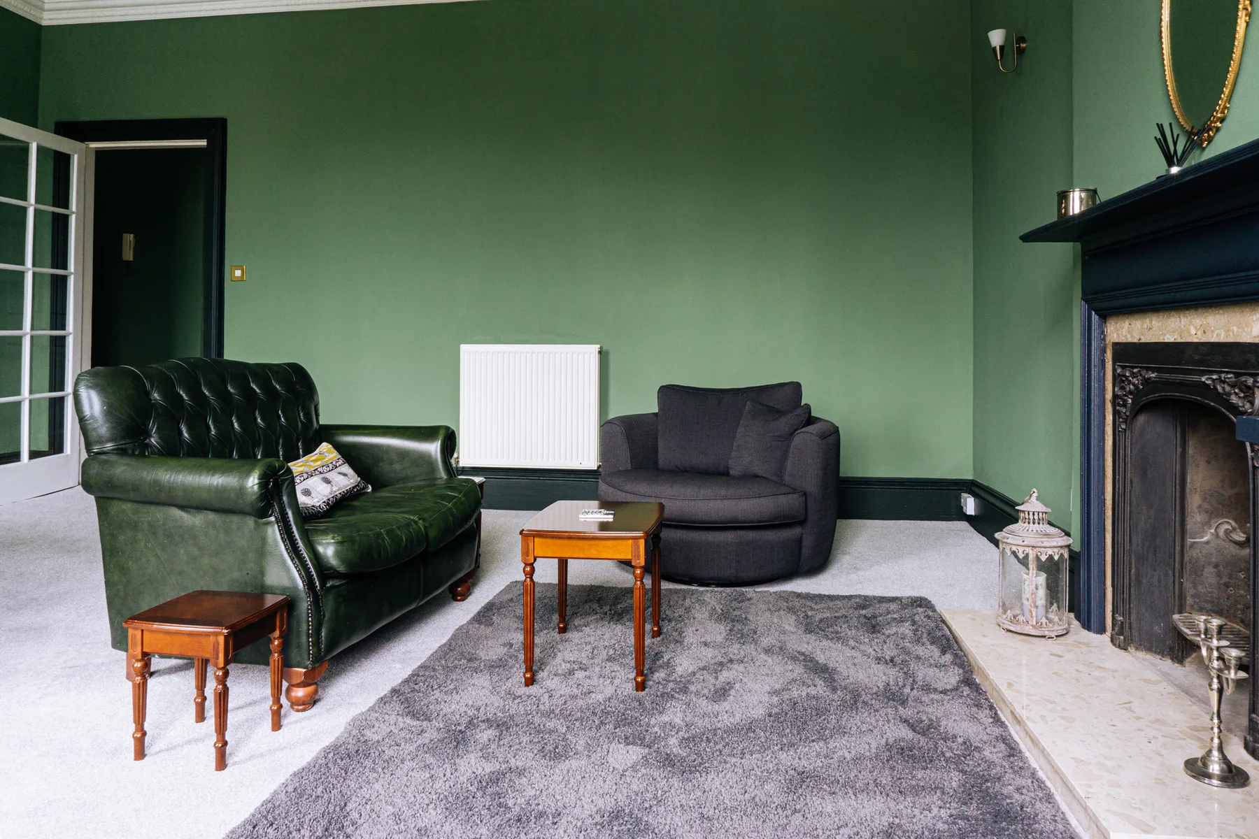 Una sala de estar con asientos alrededor de una mesa pequeña y una chimenea.