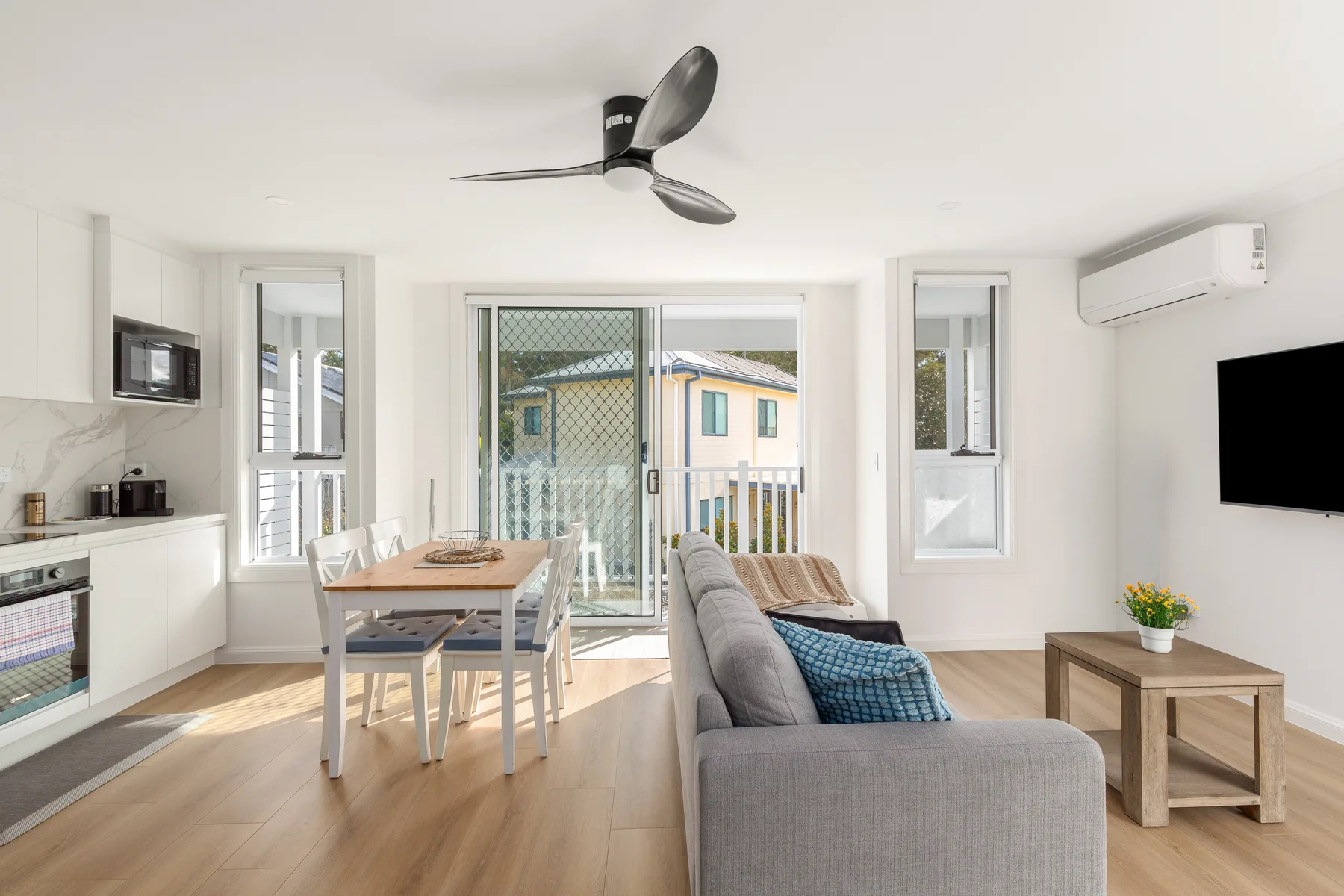 Una sala-comedor de planta abierta con cocina y puertas corredizas de vidrio.