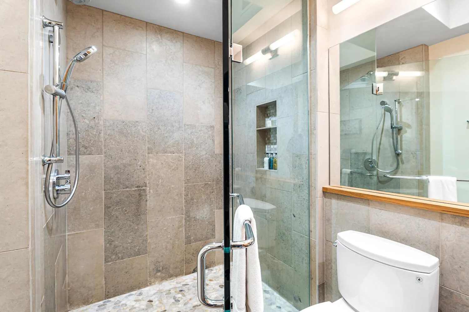 Un baño alicatado con una ducha de vidrio y un inodoro.