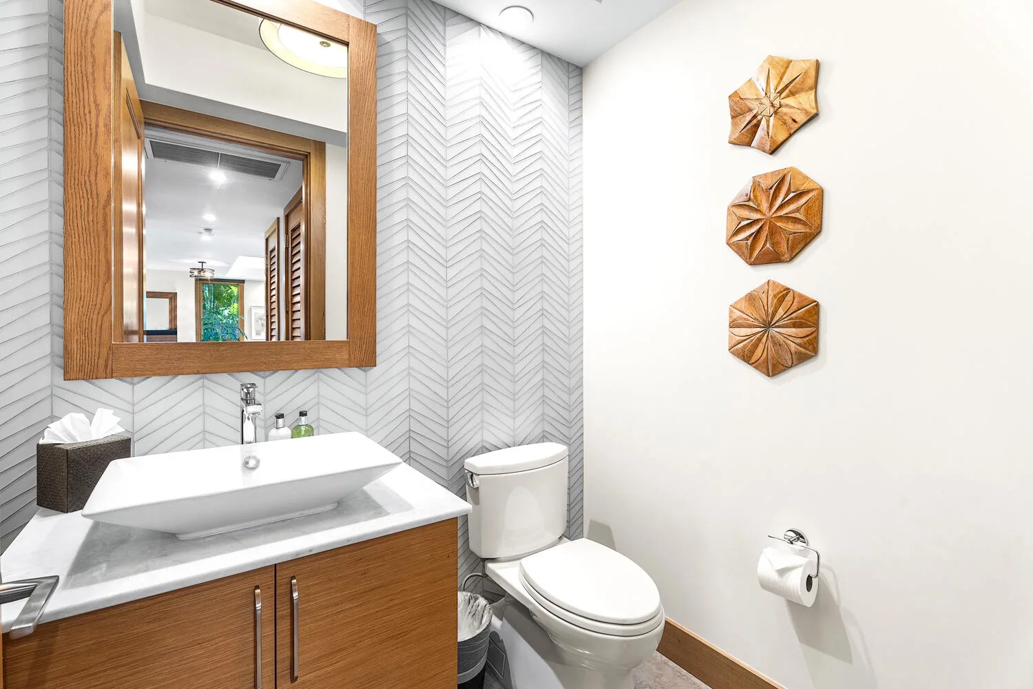 Un baño con lavabo, inodoro y piezas decorativas en la pared.