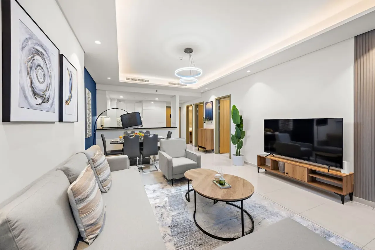 Una sala luminosa con asientos, una mesa de centro y un televisor.