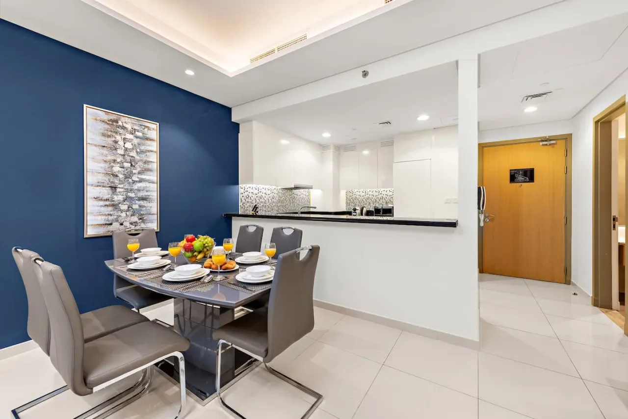 Un comedor con la mesa puesta junto a una barra de cocina blanca.