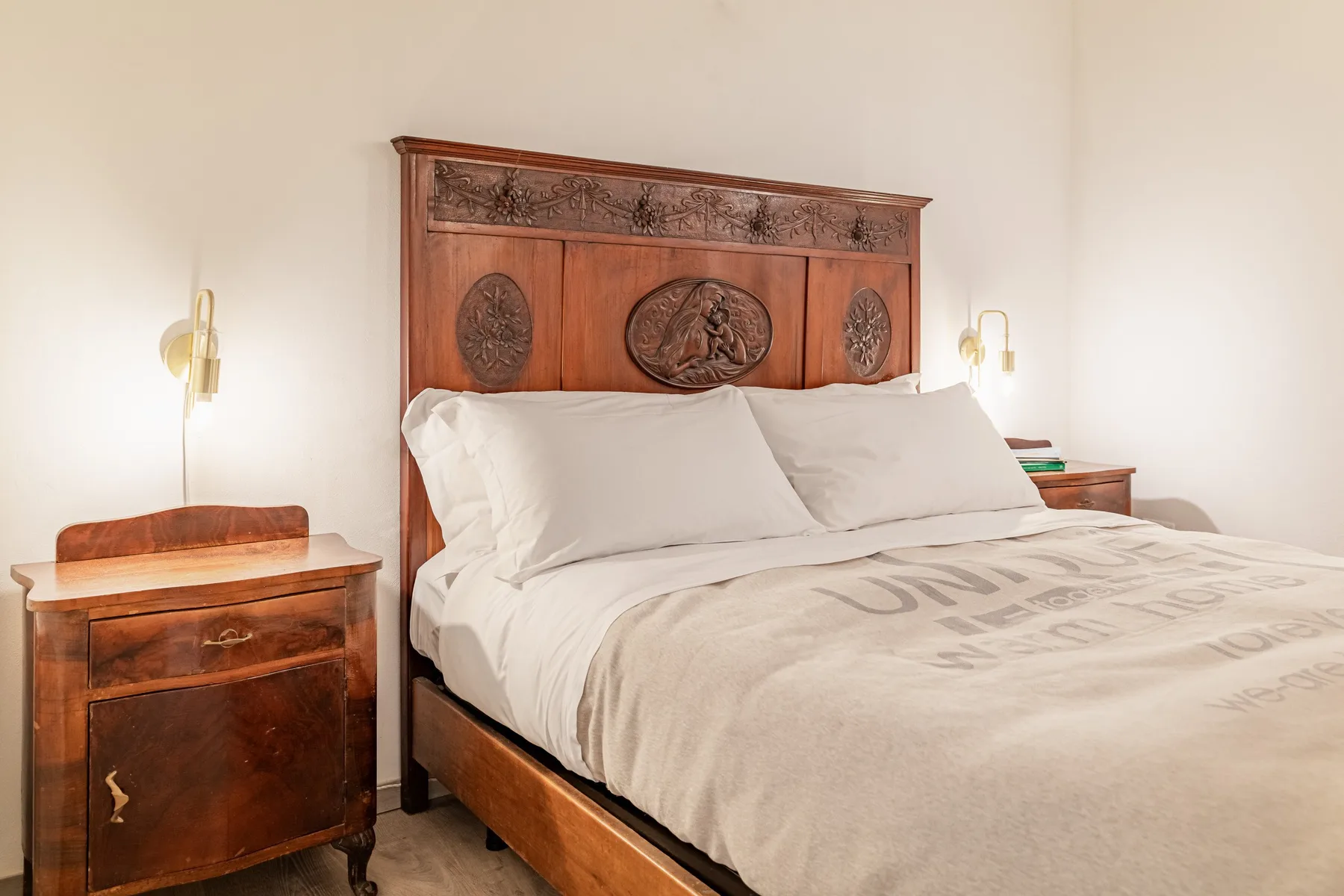 Un dormitorio con una cama grande y un cabecero de madera ornamentado.