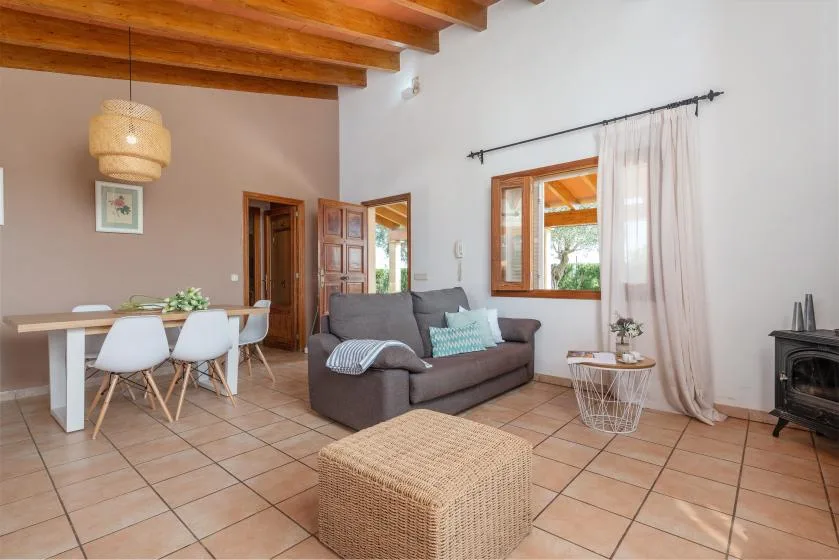 A living and dining area with a sofa, table, and tiled floor.