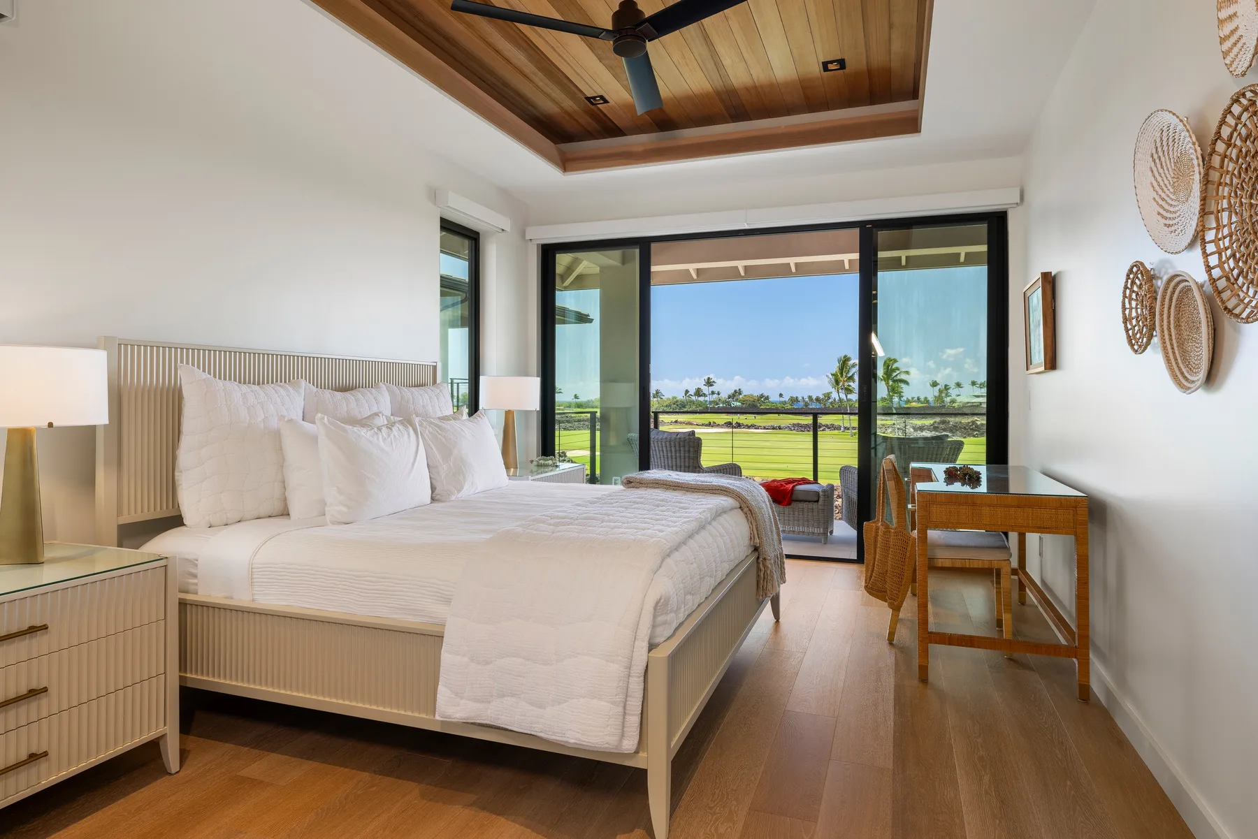 Un dormitorio luminoso con una cama grande y puertas corredizas de vidrio que dan a un patio.
