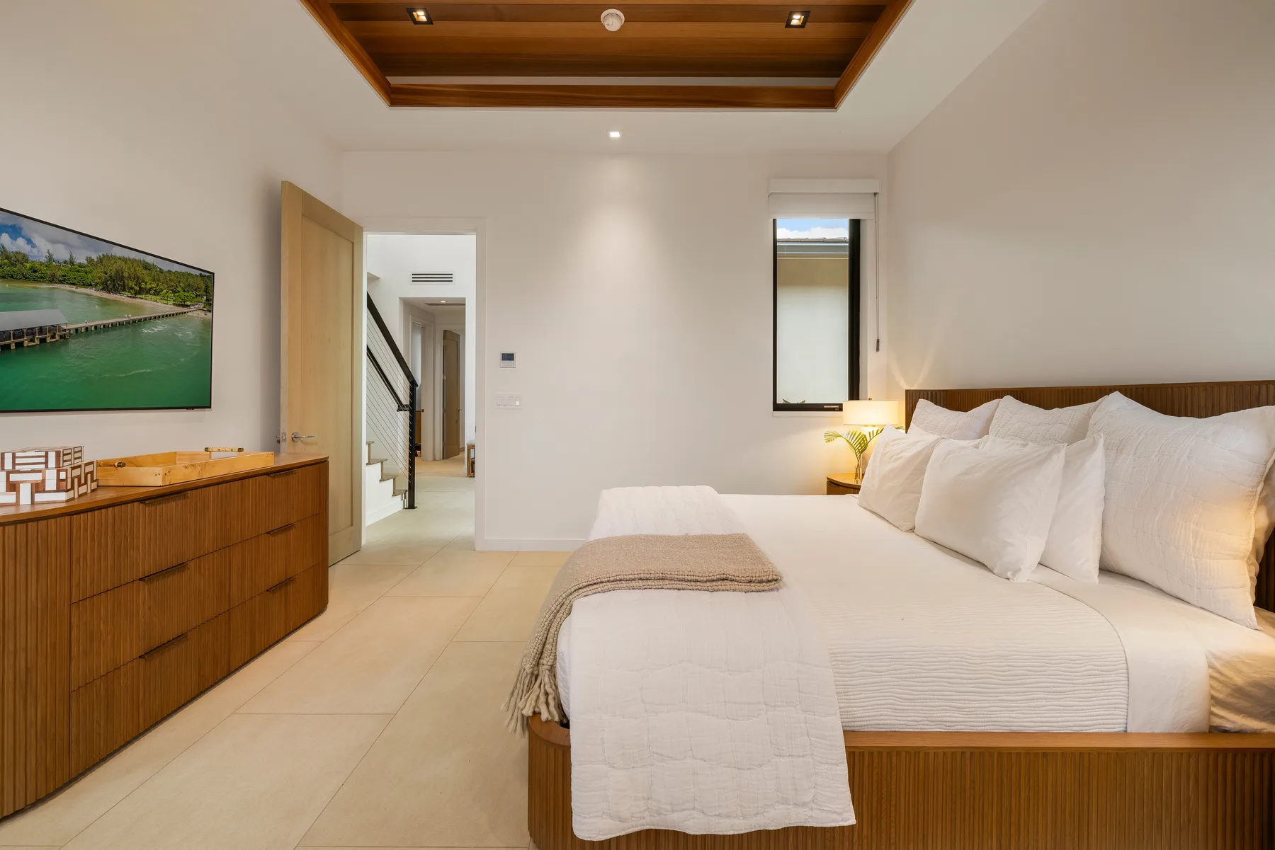 Un dormitorio con una cama grande, una lámpara de noche y un mueble de madera.