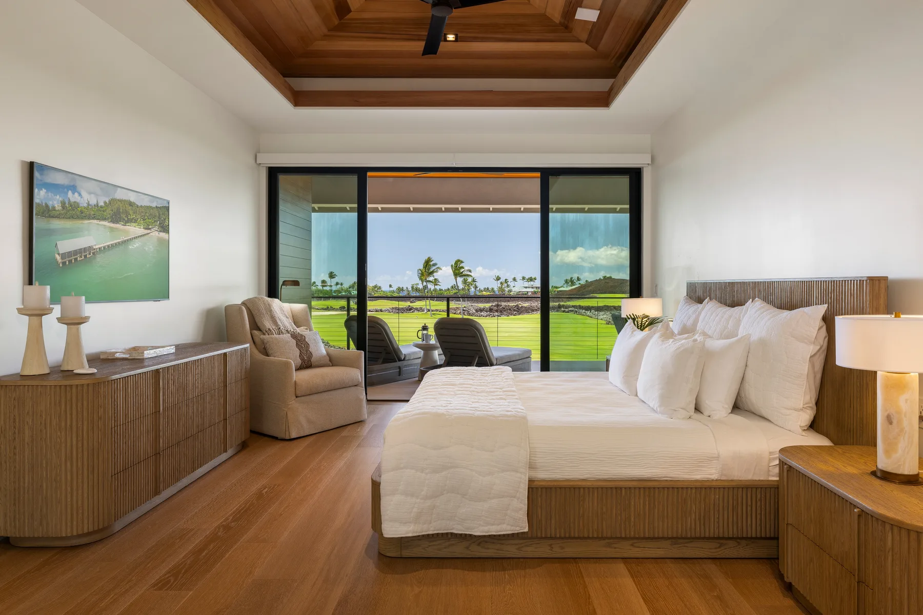 Un dormitorio con una cama grande y puertas corredizas de vidrio con vistas verdes.