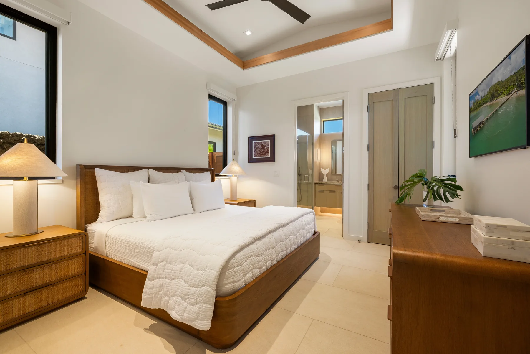 Un dormitorio luminoso con una cama bien hecha y una cómoda de madera.