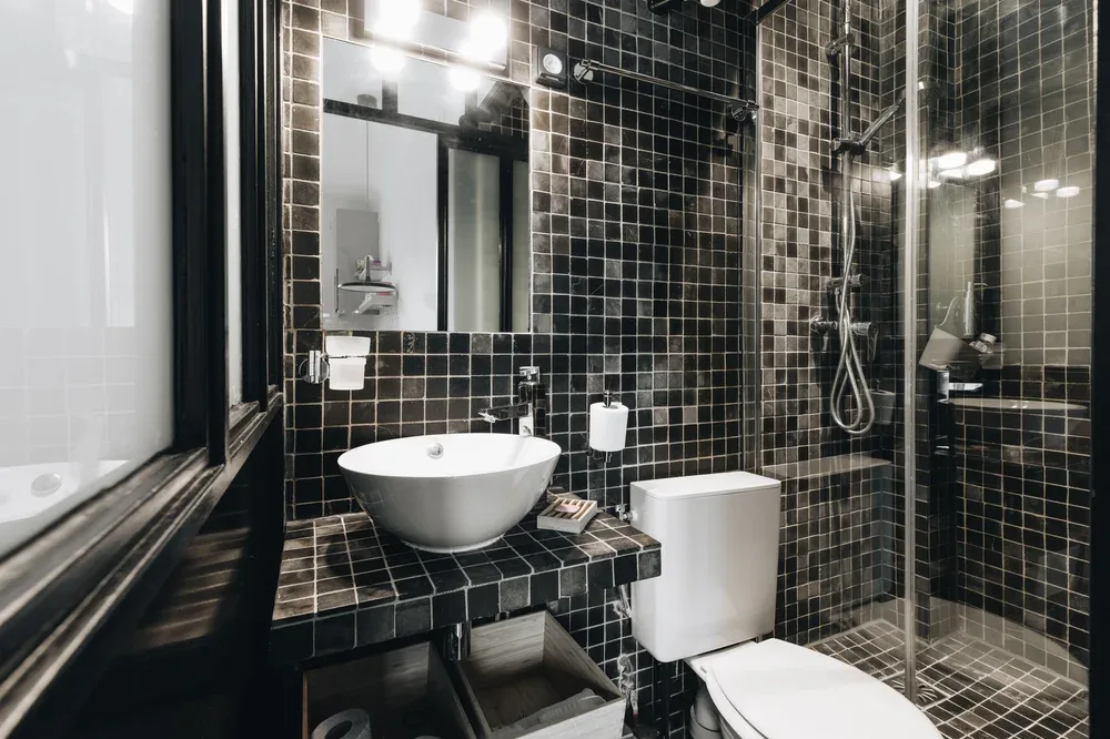 A tiled bathroom with a sink, toilet, and glass shower.