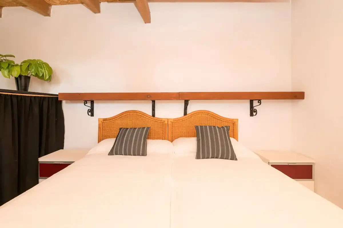 A bedroom with a large bed, striped pillows, and a wooden headboard.