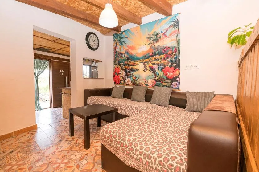 A lounge with patterned seating, a small table, and colorful wall art.