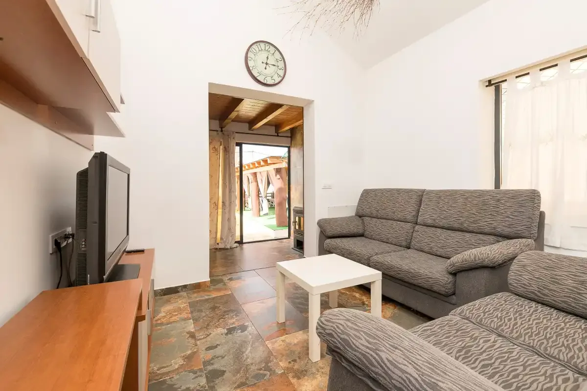 A living room with seating, a television, and a small coffee table.