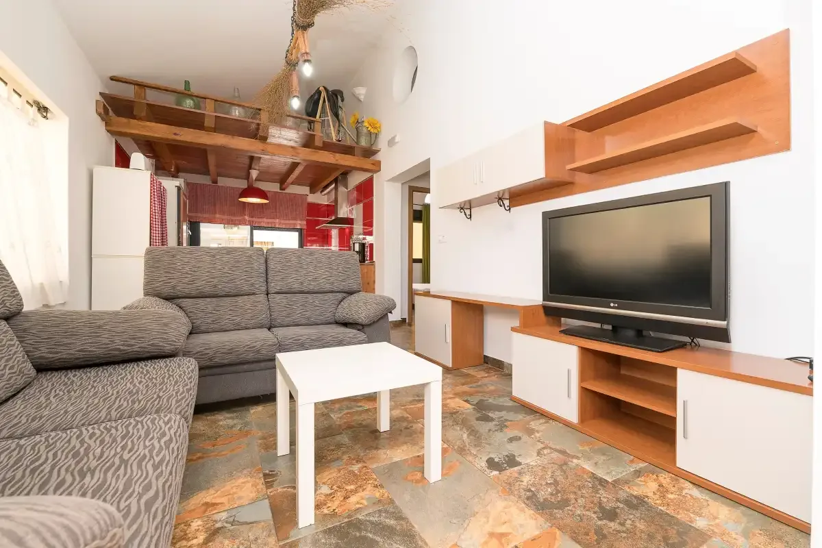 A living room with seating, a coffee table, and a television.