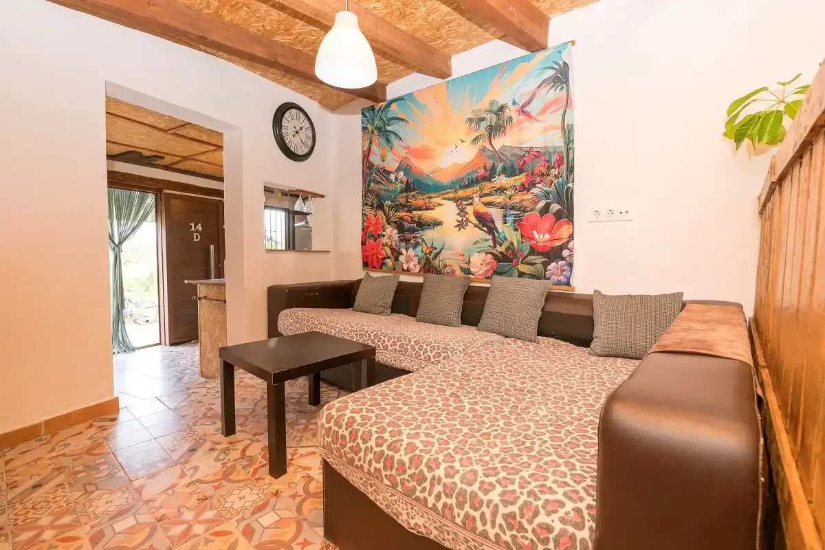 A lounge area with patterned seating and a colorful tropical wall mural.
