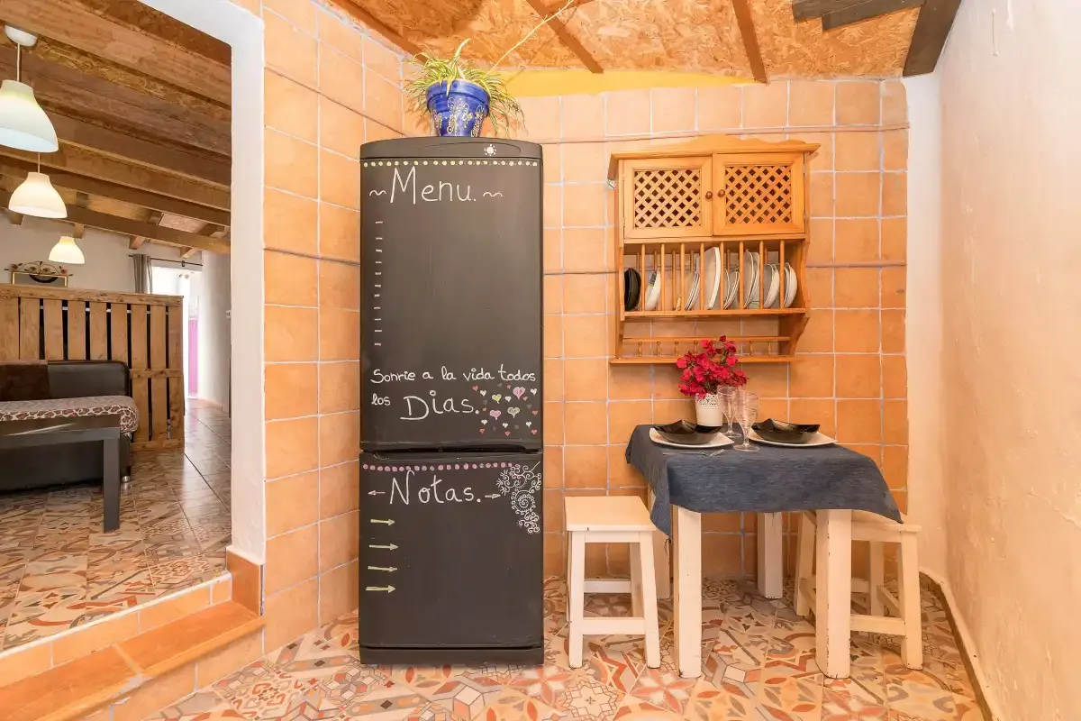 A tiled dining nook with a small table and a chalkboard menu.