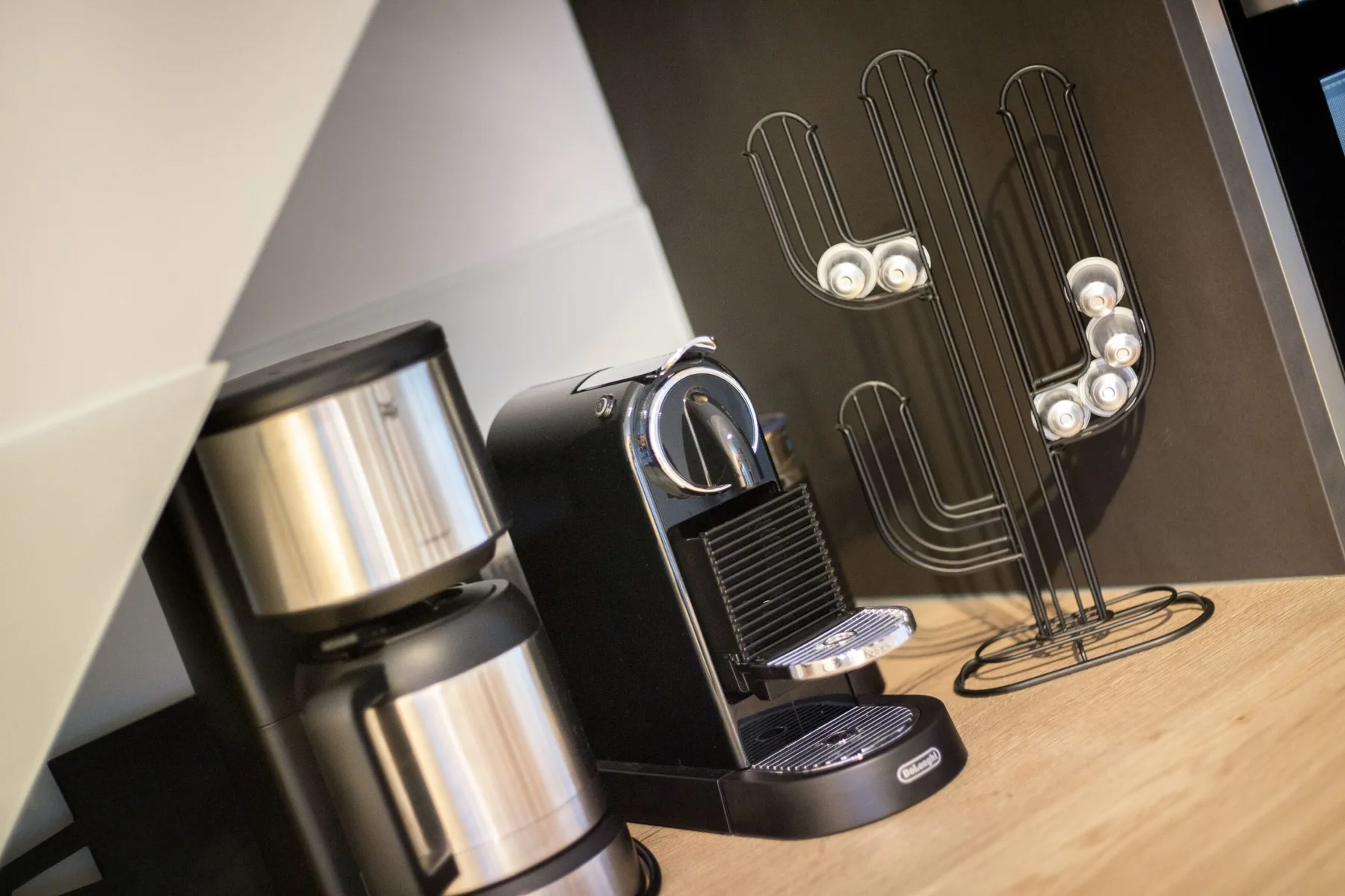 A coffee station with a drip coffee maker and a capsule espresso machine.