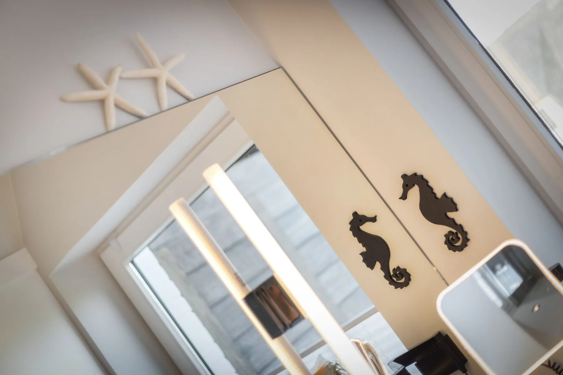 A bright bathroom with seahorse decorations on the wall.