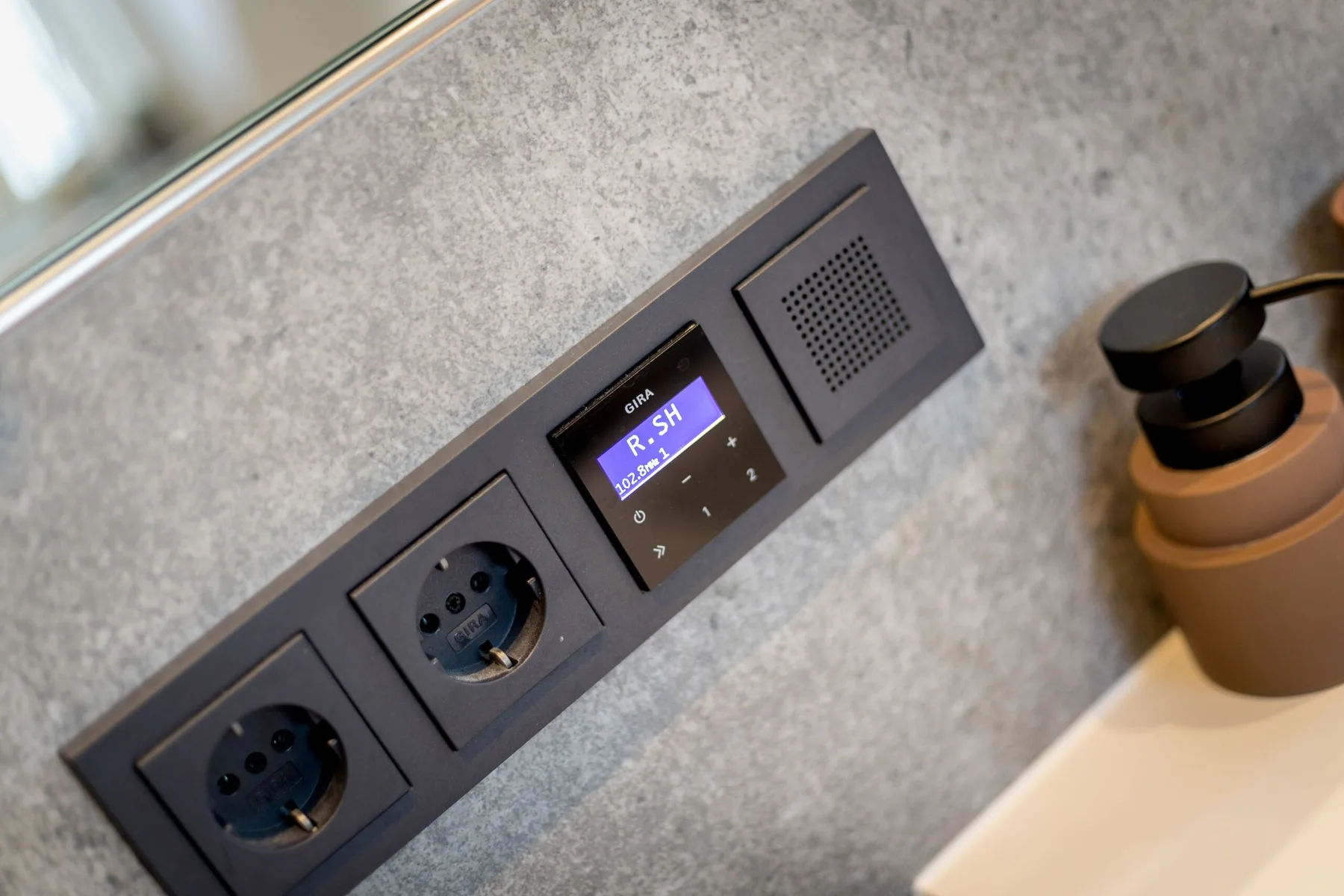 A wall-mounted control panel with electrical outlets and a digital display.