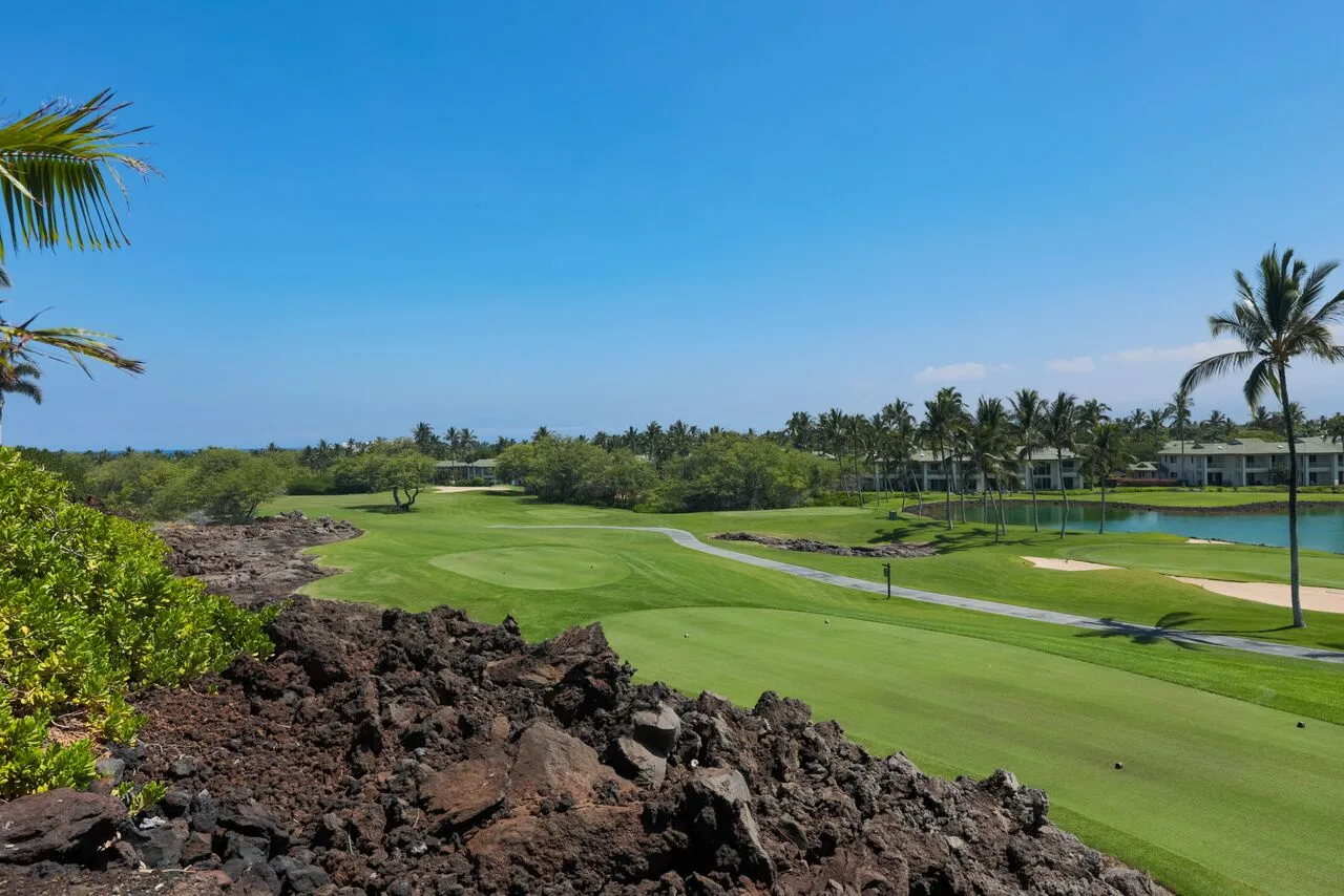 Un campo de golf ajardinado se extiende bajo un cielo despejado.