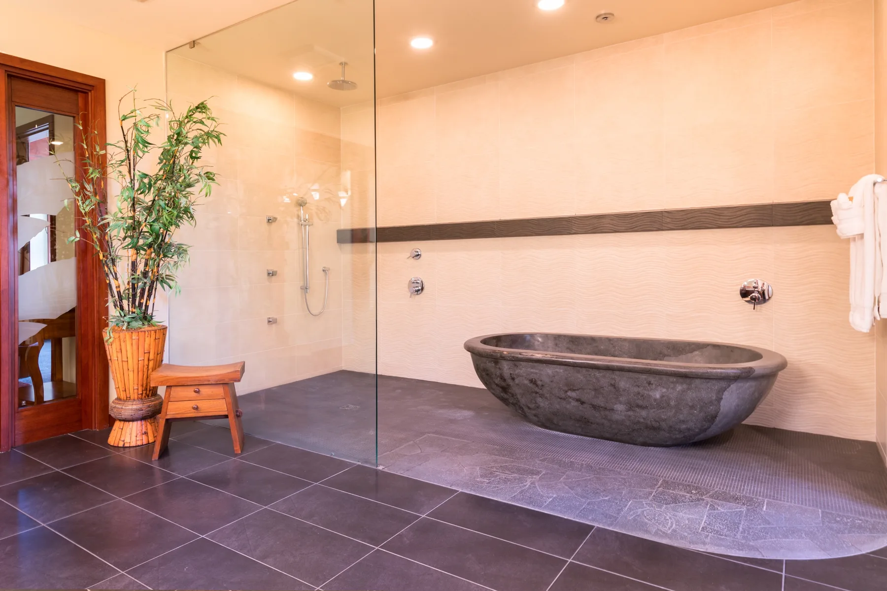 Un baño con una bañera exenta y una zona de ducha con panel de vidrio.