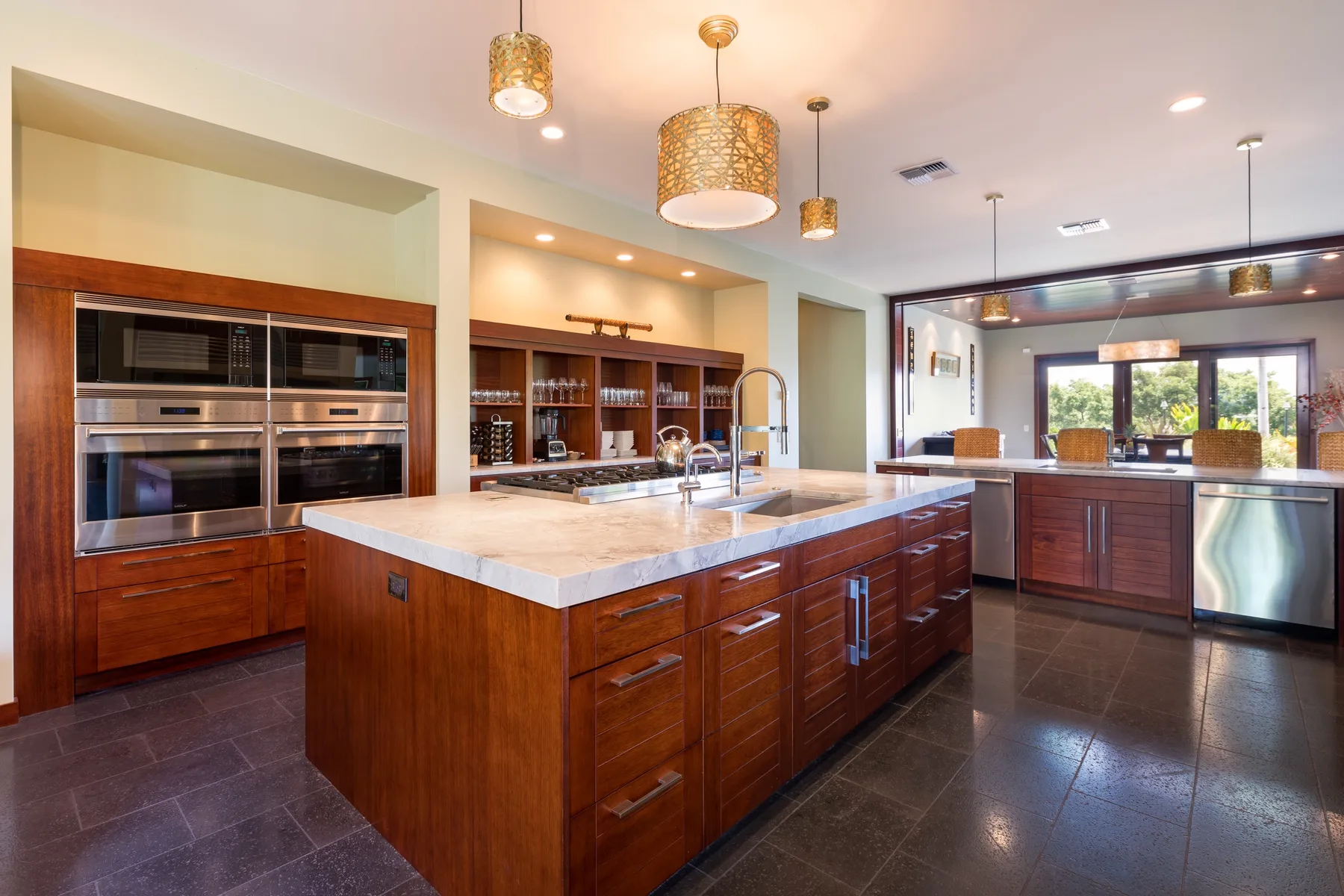 Una cocina amplia con una gran isla central y gabinetes de madera oscura.