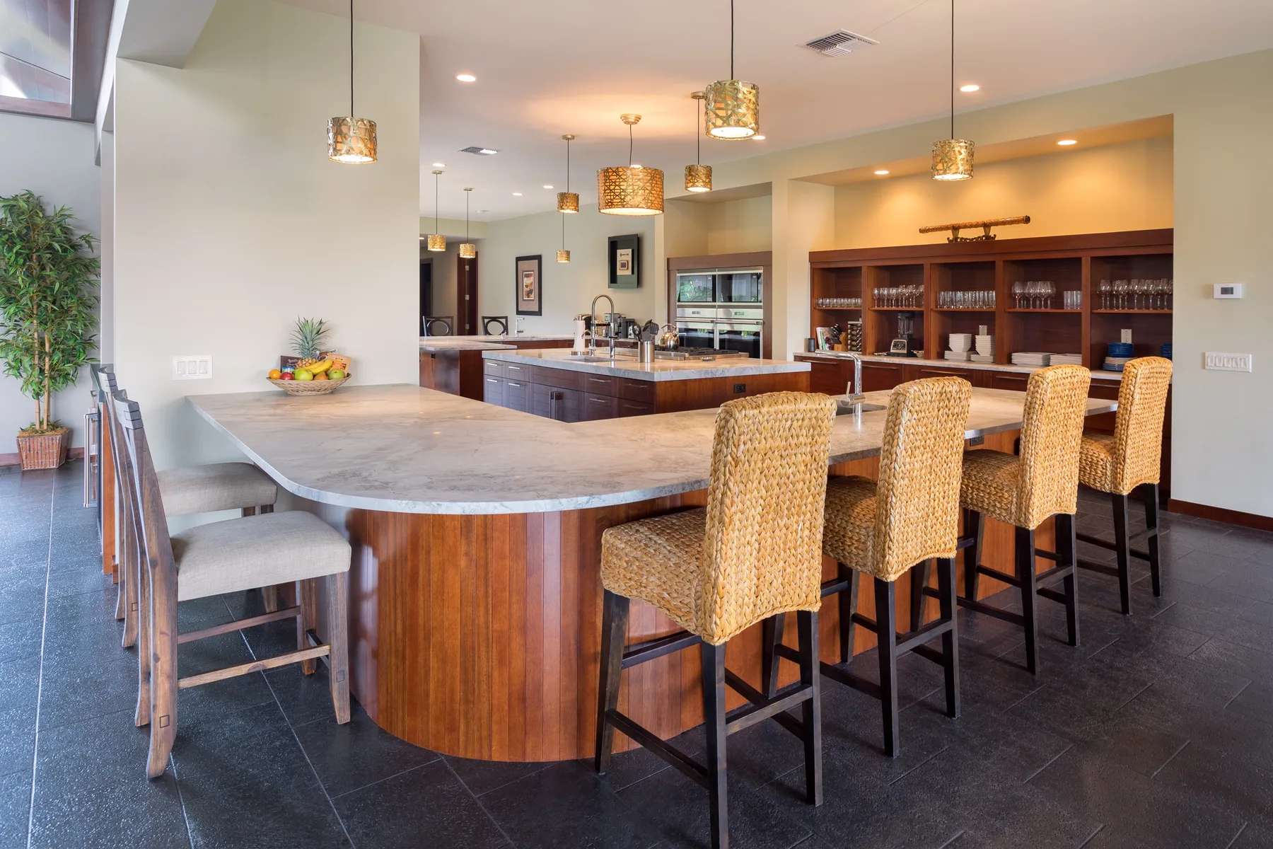 Una amplia cocina y comedor con una isla grande y asientos tejidos.