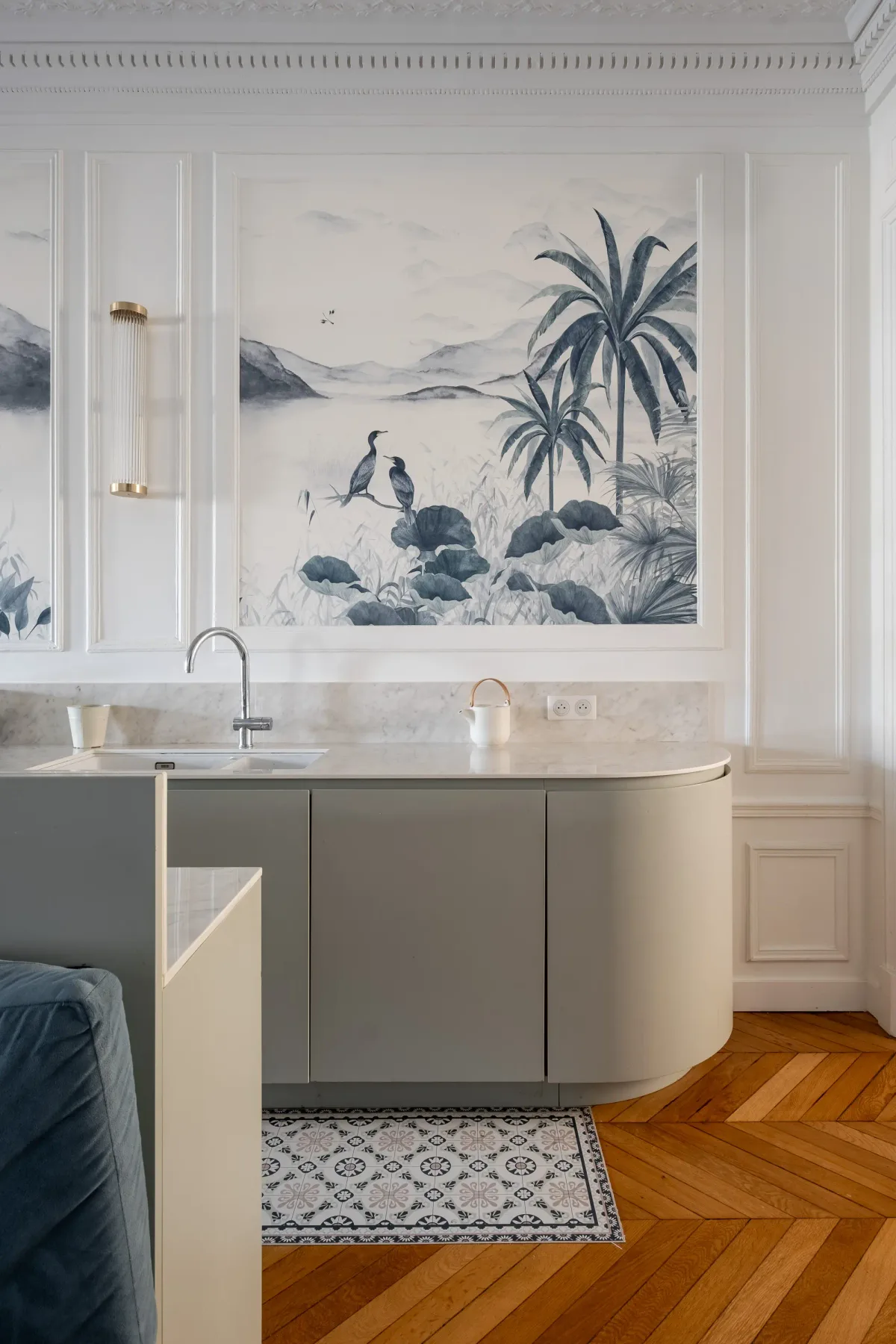Un tocador de baño está bajo un gran mural paisajístico enmarcado.