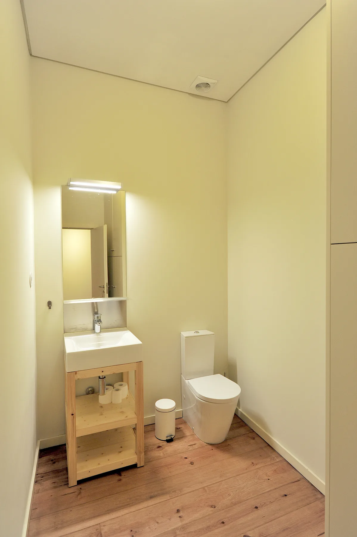 Un baño con lavabo, espejo e inodoro.