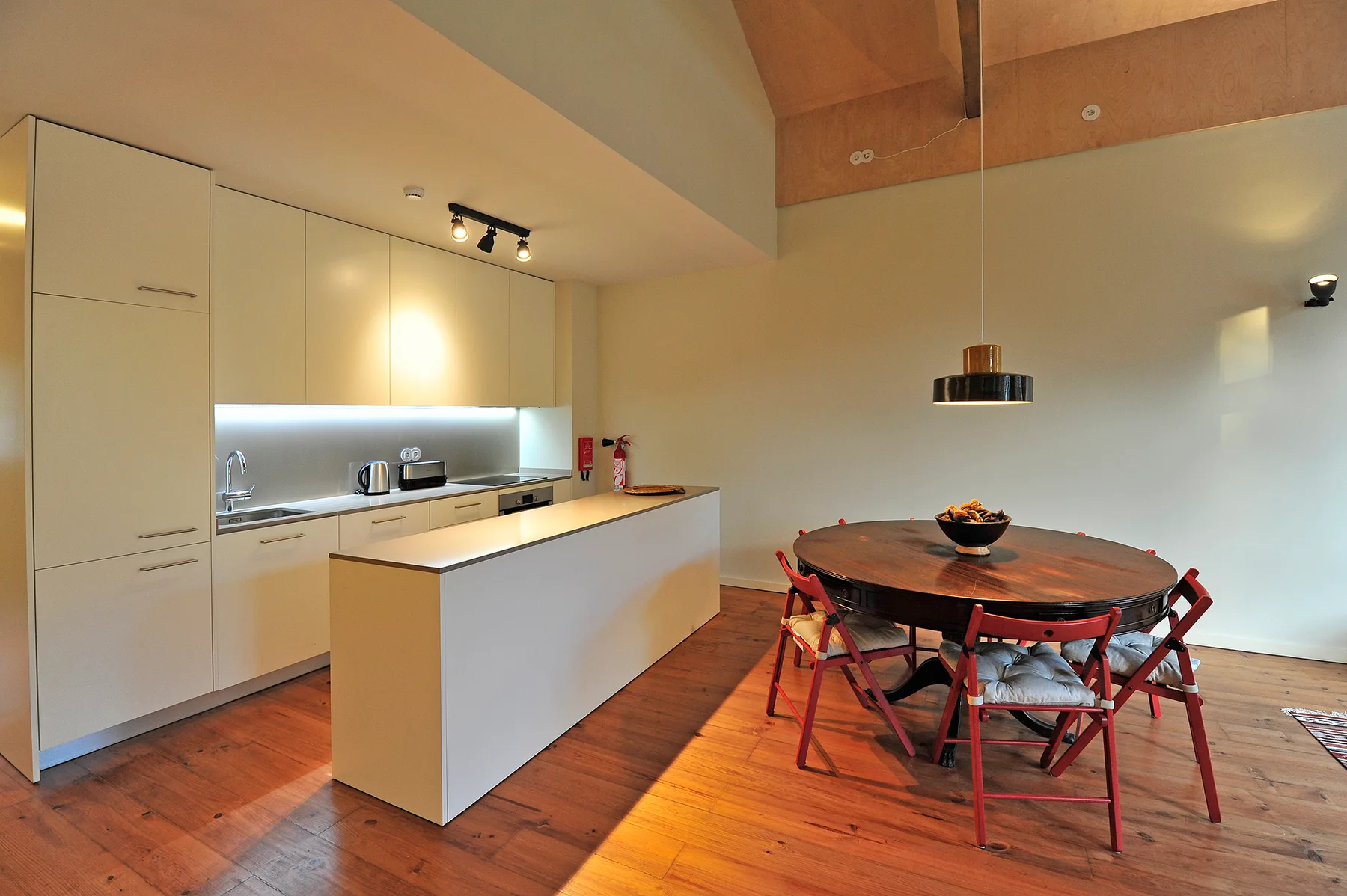An open kitchen and dining area with a central island and round table.