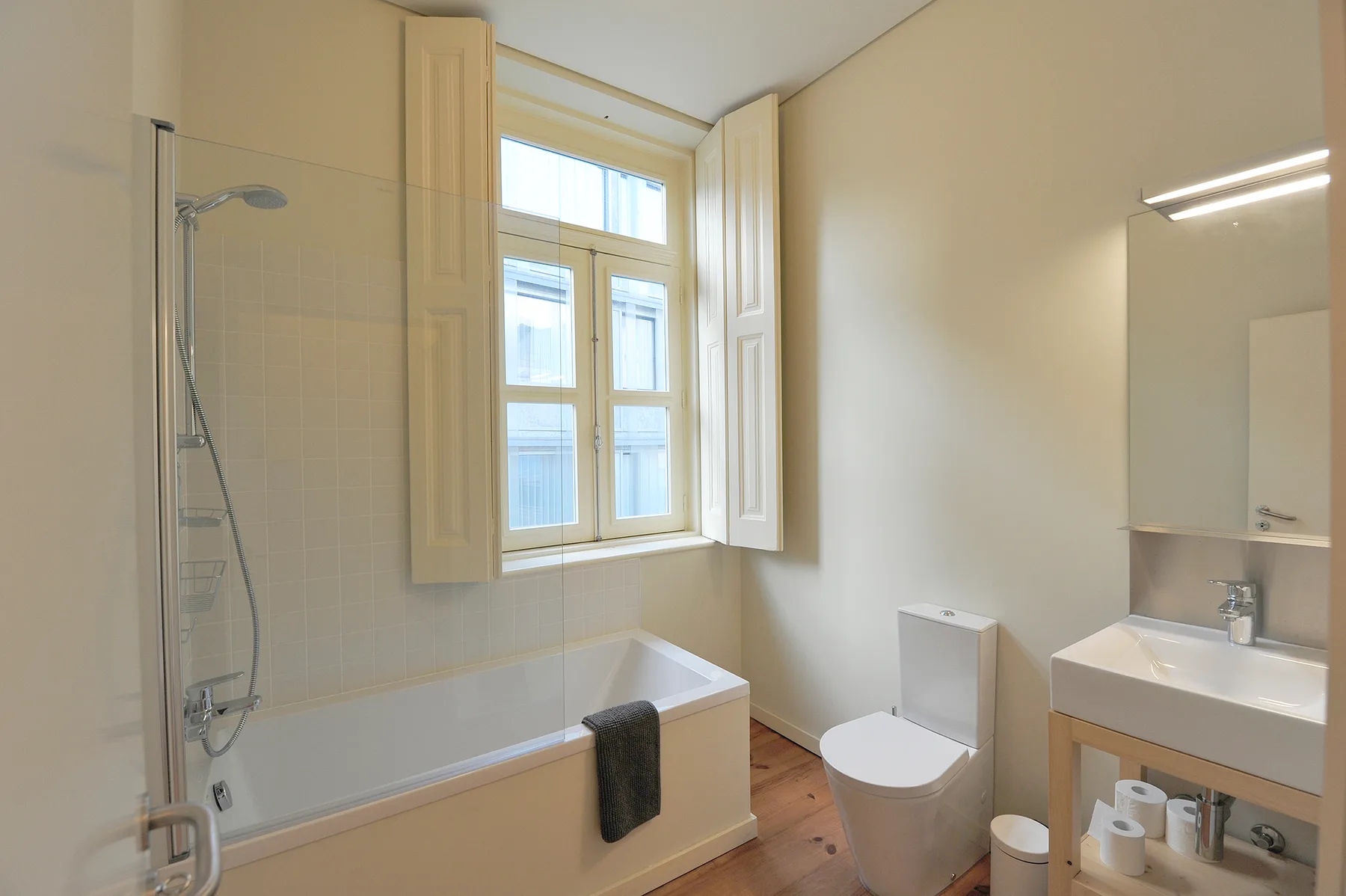 Un baño luminoso con bañera, ducha, inodoro y lavabo.