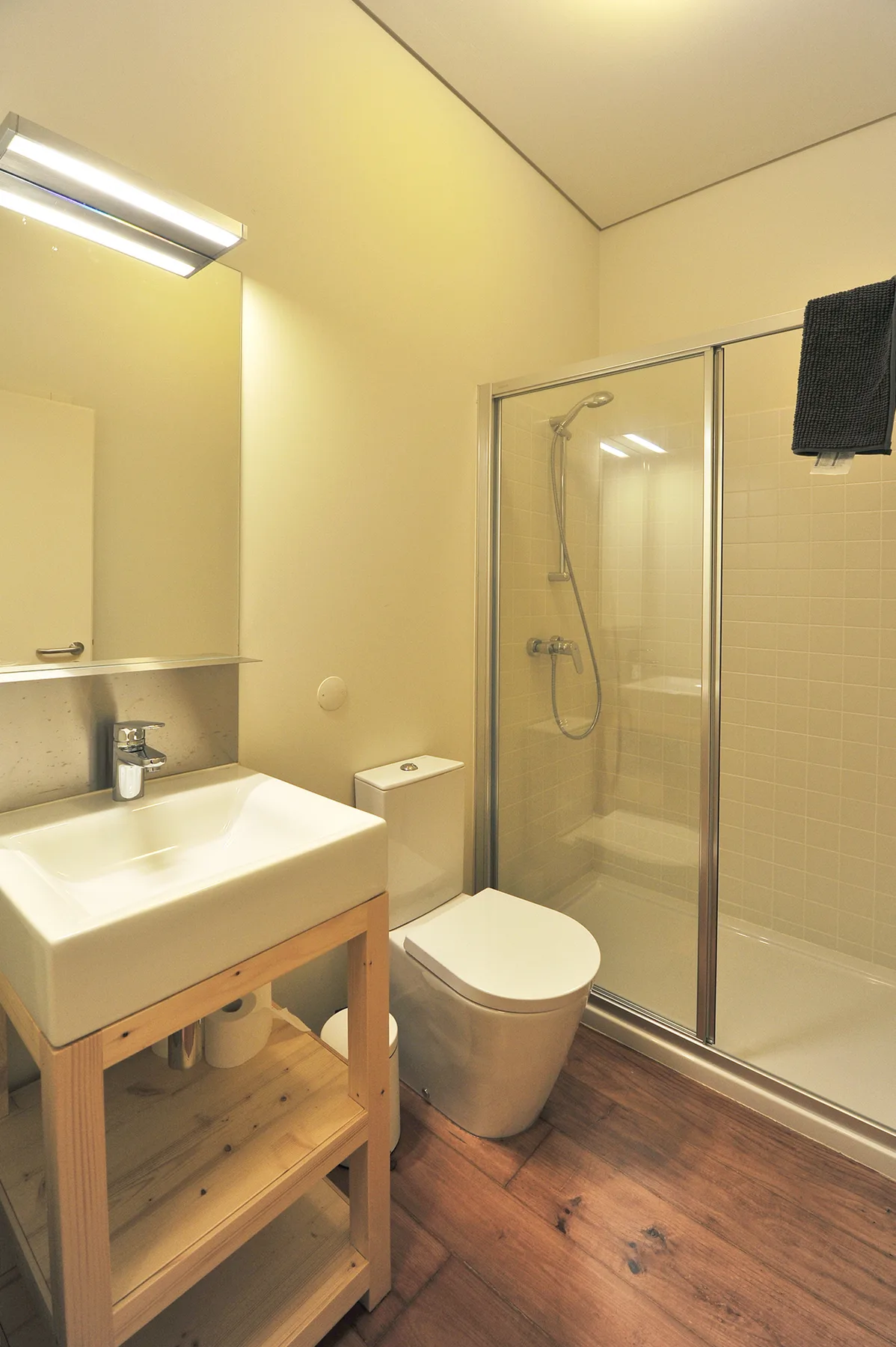 Un baño con lavabo, inodoro y ducha con mampara de vidrio.