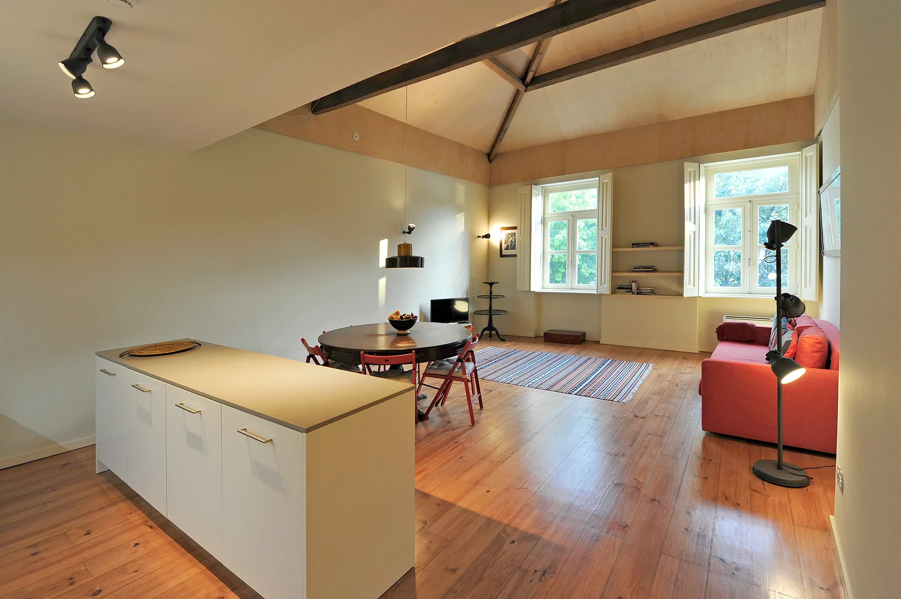 A bright open-plan living and dining area with a kitchen island and large windows.