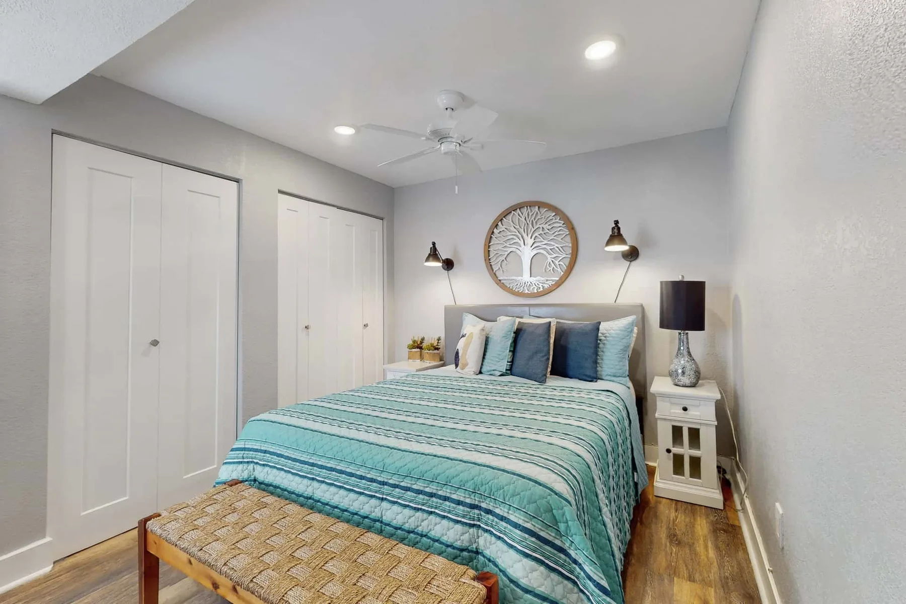 Dormitorio con una cama vestida con ropa de cama azul y blanca.