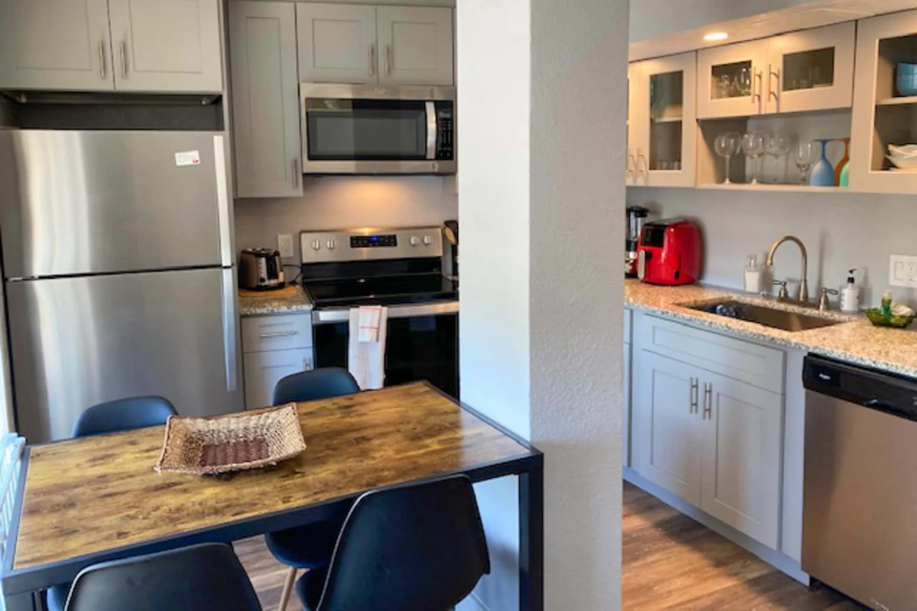 Una cocina con mesa de comedor, electrodomésticos de acero inoxidable y un fregadero en la encimera.