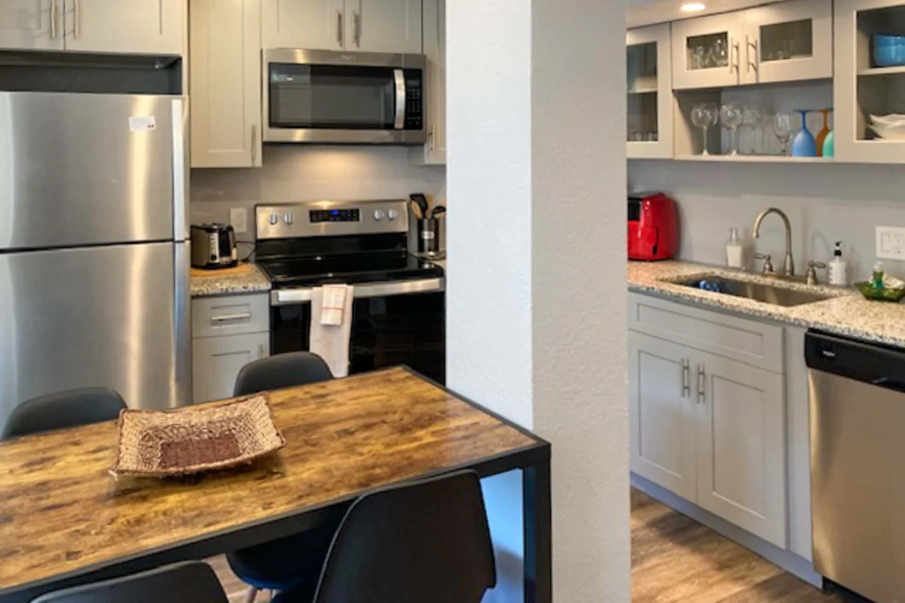 Una cocina y comedor con una mesa de madera junto a la encimera.