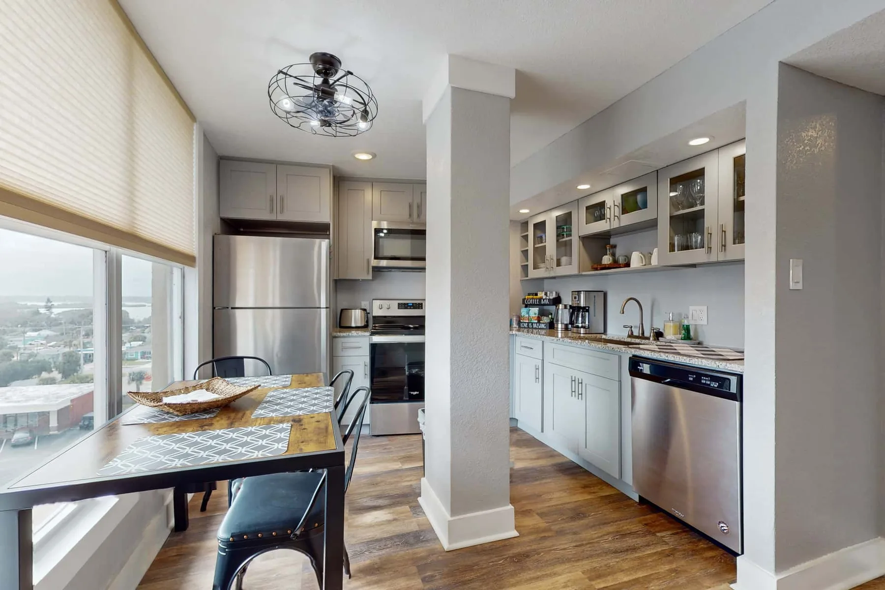 Una cocina moderna con una mesa de comedor junto a grandes ventanas.