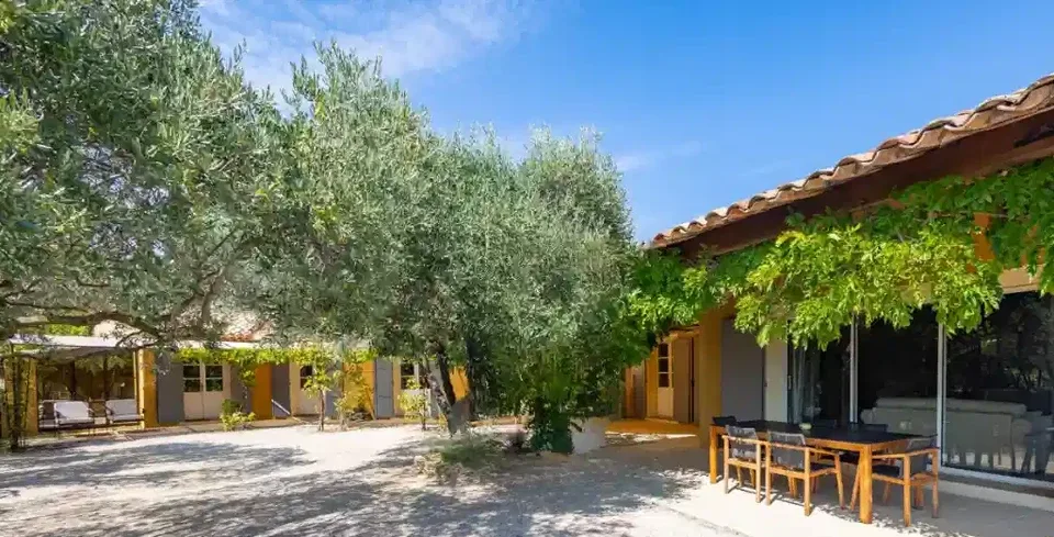 Vista exterior de la casa con terraza y árboles