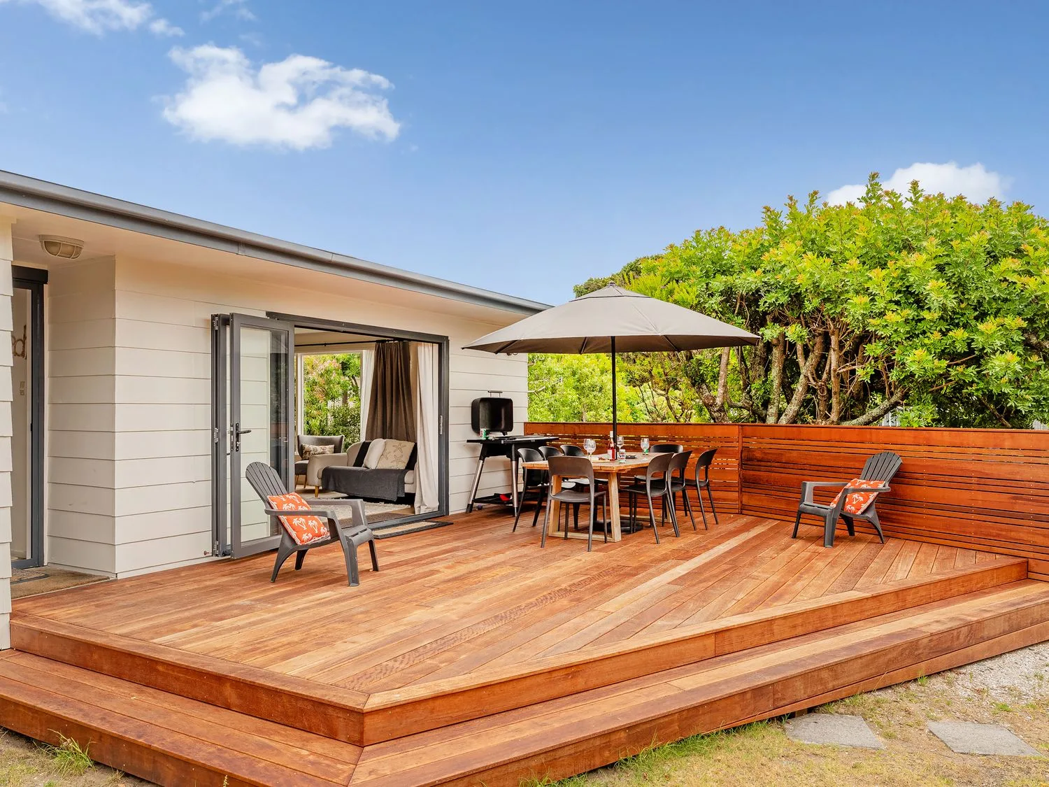 An outdoor deck with a table and chairs at Slice of Pauanui - Pauanui Holiday Home, Pauanui