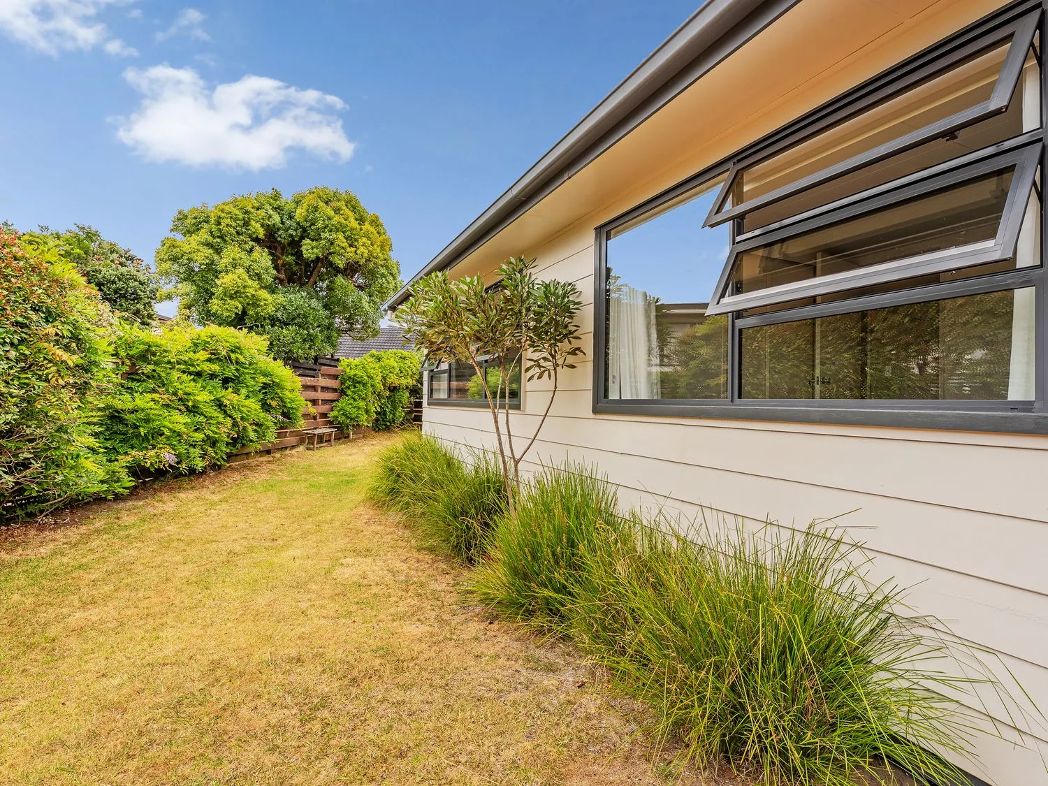 An outdoor area with a house and greenery at Slice of Pauanui - Pauanui Holiday Home, Pauanui
