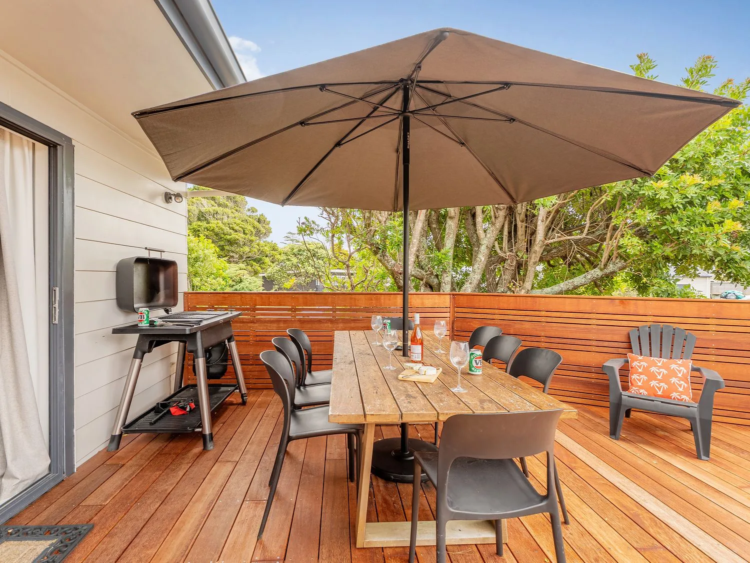 An outdoor dining area with a table and chairs at Slice of Pauanui - Pauanui Holiday Home, Pauanui