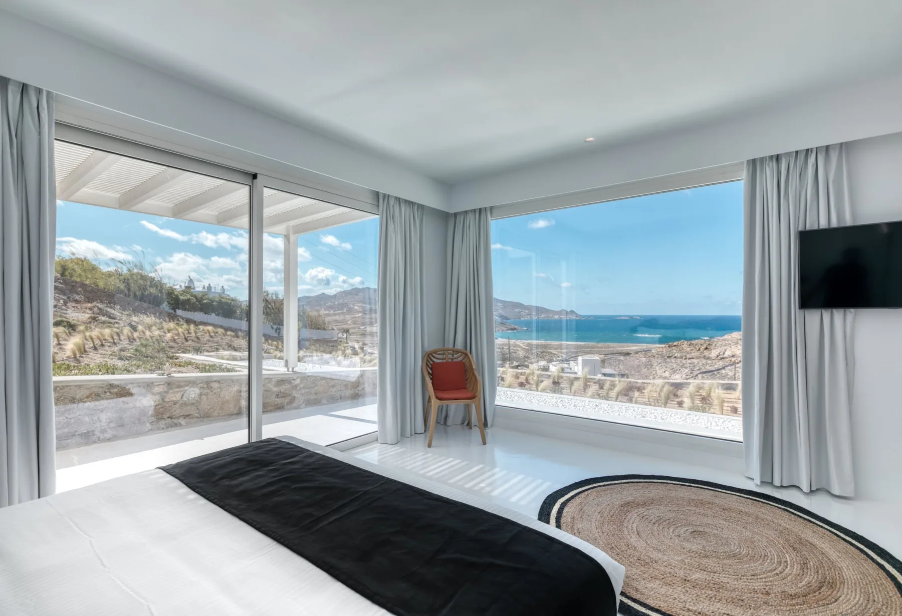 A bright room with large windows overlooking the coast.