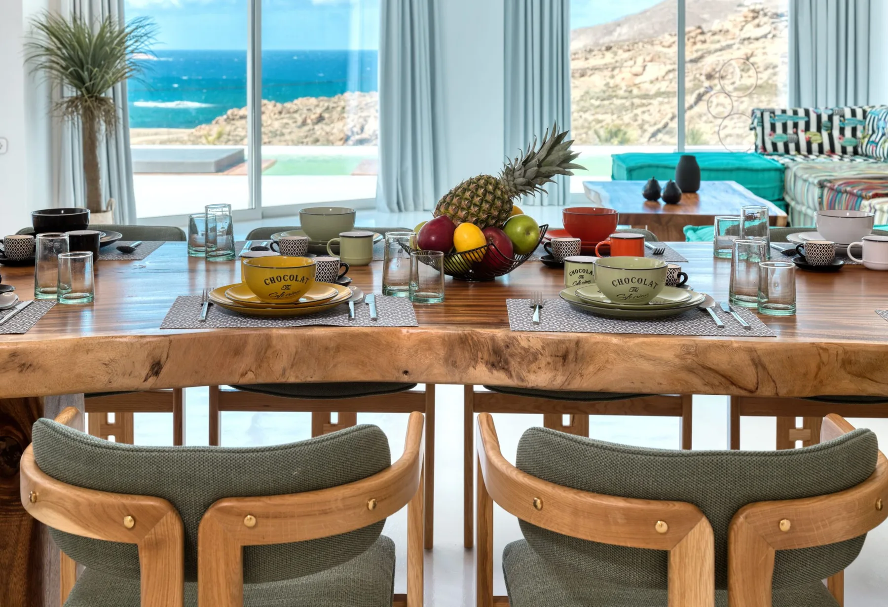 A dining area with a set table overlooking the sea.